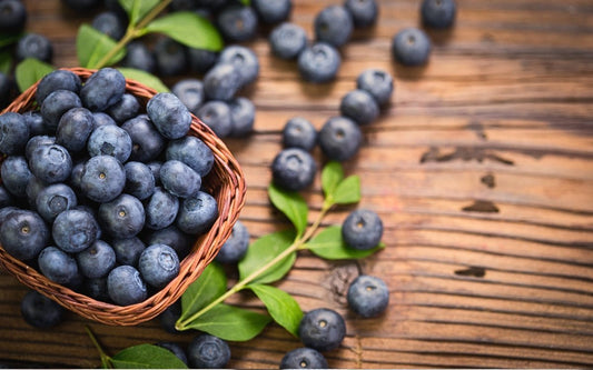 Blaubeeren in einem Körbchen auf einem Holztisch