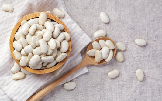 Weiße Bohnen auf Küchentisch in einer Holzschale