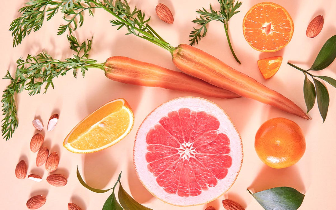 unterschiedliche, aufgeschnittene Obst- und Gemüsesorten auf einem leicht rosa Untergrund.