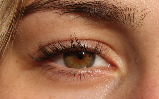 Ein strahlendes braunes Auge im close-up ist zu sehen.