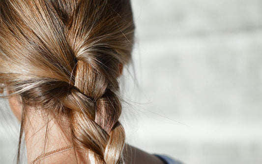 gesunde, blonde Haare zu einem Zopf gebunden