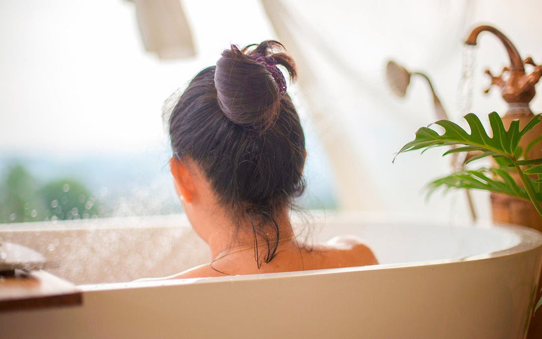 Frau sitzt in Badewanne