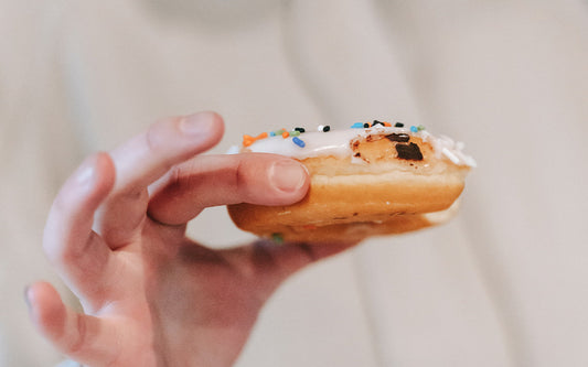 Zuckerglasierter Donut in einer Hand