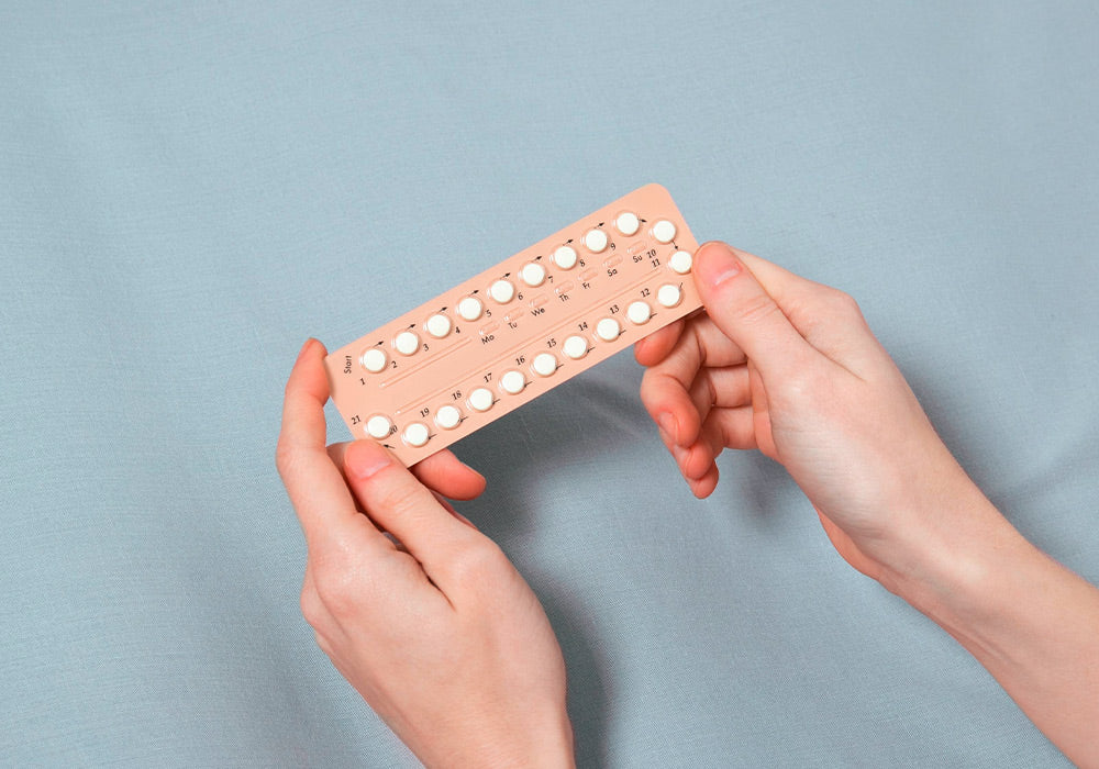 rosa Pillenpackung, die von 2 Frauenhänden gehalten wird.