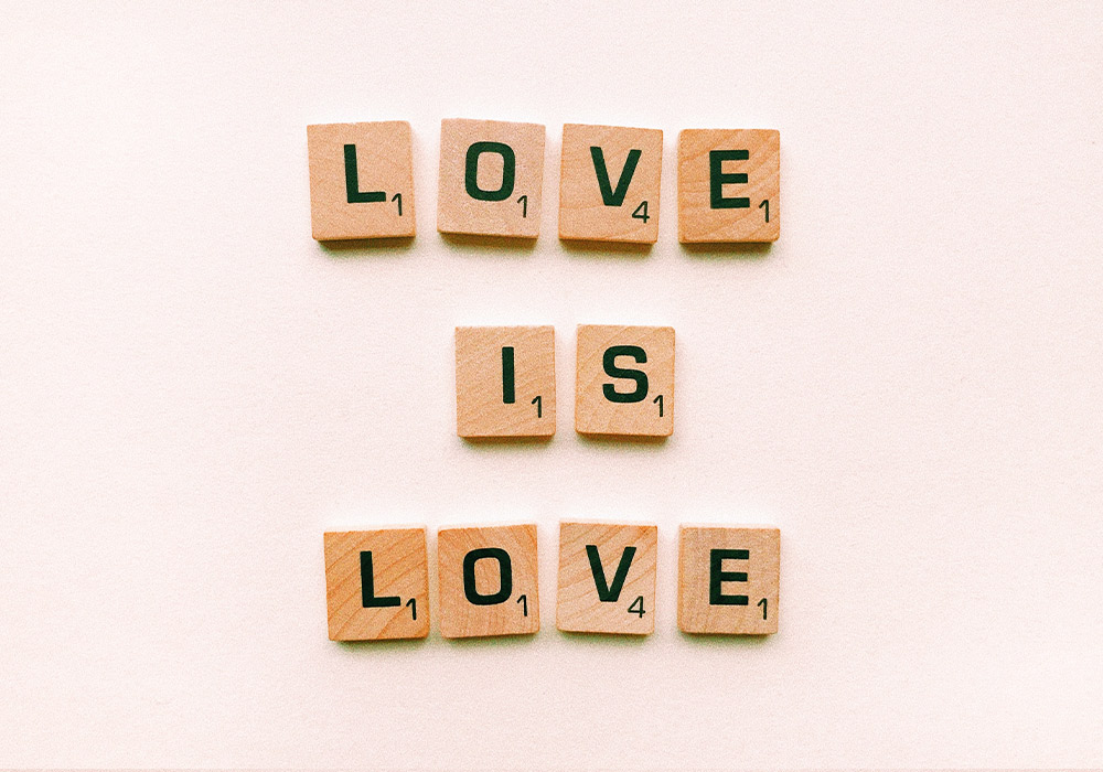 mit Buchstaben bedruckte Holzplättchen bilden die Worte "Love is Love"