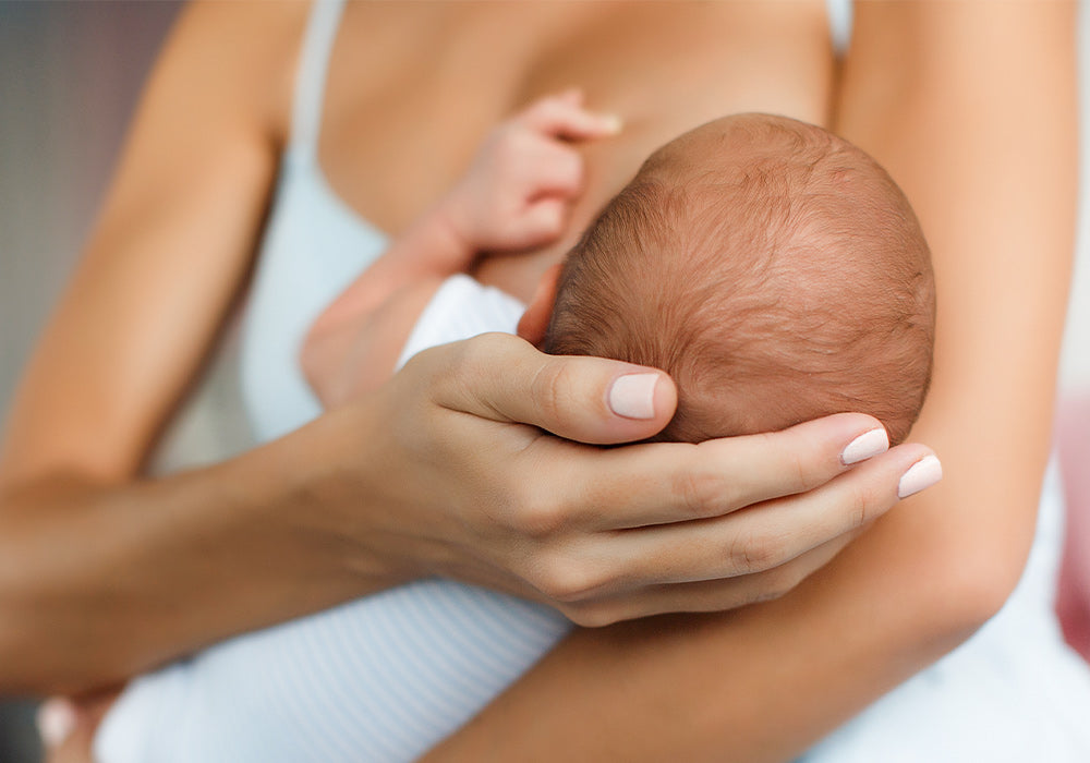 Stillende Mutter mit Baby auf dem Arm