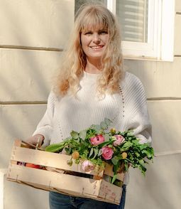 Julia hält Kiste mit Blumen