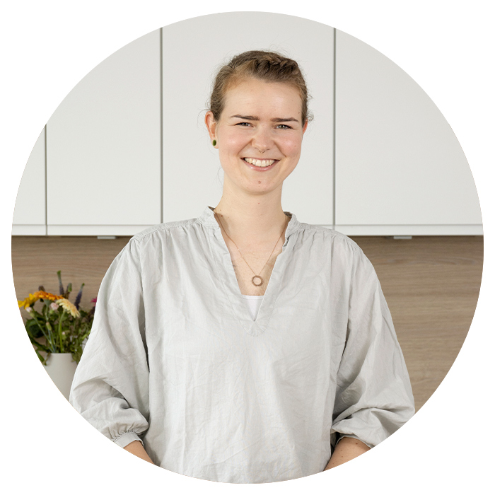 Lachende Frau steht in der Küche