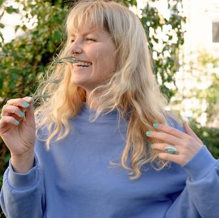 Julia riecht an einer Blume