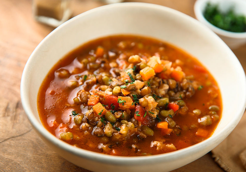 Weiße Schale mit veganer Suppe aus Linsen und Gemüse