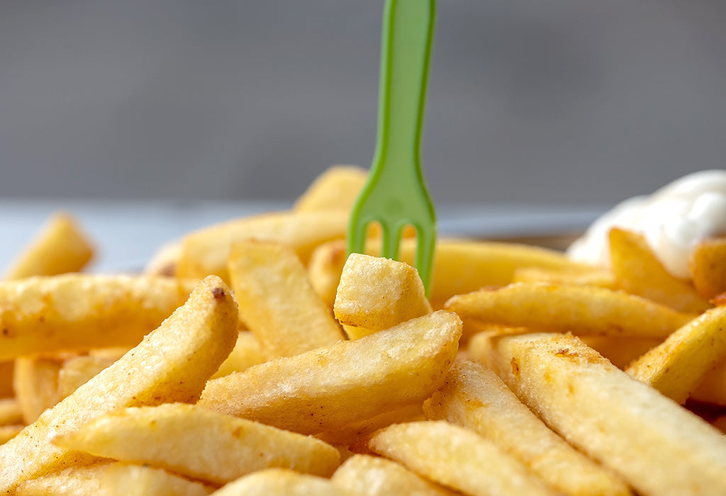 Ein Teller Pommes mit einer Gabel.