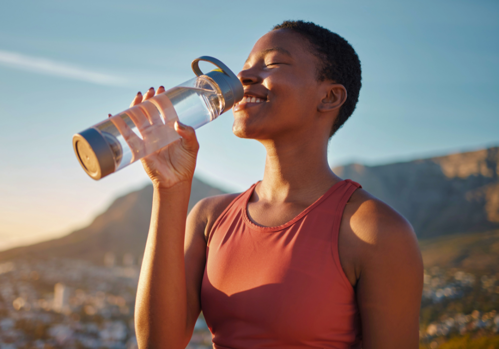 Frau trinkt Wasser nach Sport